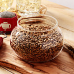 Bol rempli de graines d&rsquo;orge grill&eacute;es (mugicha) sur une surface en bois